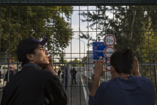 SERBIA, Horgos: Refugees peer onto the Hungarian side of the Serbia-Hungary border through a fence after Hungary closed the border crossing on September 16, 2015.****Restriction: Photo is not to be sold in Russia or Asia****
