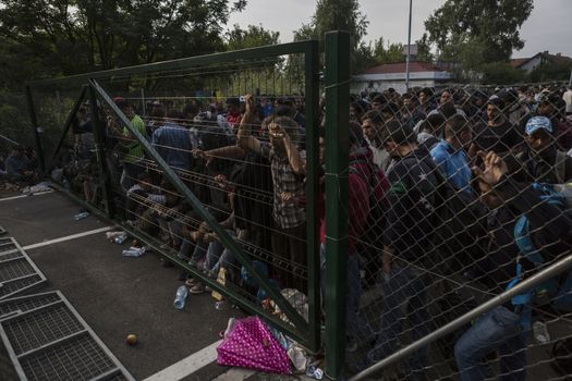 SERBIA, Horgos: Refugees stand behind a fence on the Serbian side of the Serbia-Hungary border after Hungary closed the border crossing on September 16, 2015.****Restriction: Photo is not to be sold in Russia or Asia****