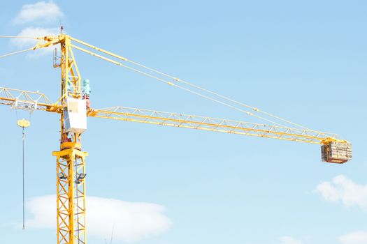 Yellow Industrial crane and blue sky on construction site or seaport