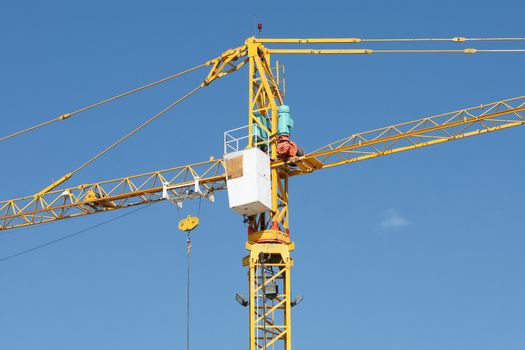 Yellow Industrial crane and blue sky on construction site or seaport