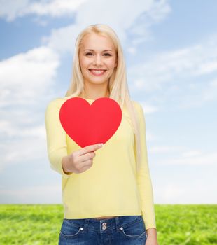 happiness, health and love concept - smiling woman with red heart