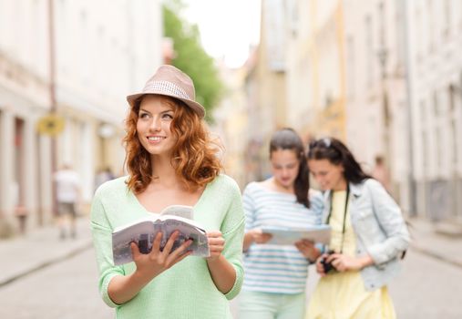 tourism, travel, holidays and friendship concept - smiling teenage girls with city guide, map and camera outdoors