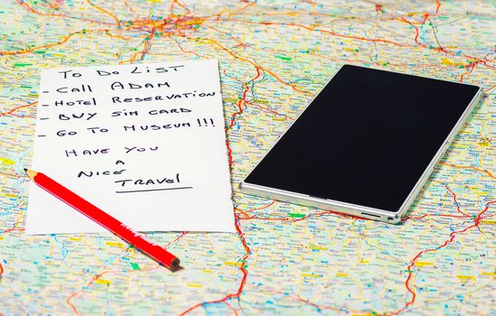 In the pictured a map, a pencil , a phone / tablet and a list of things to do .