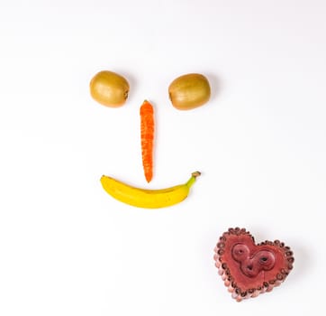 This smiley is made wirh carrot,kiwi and banana,below heart candle.