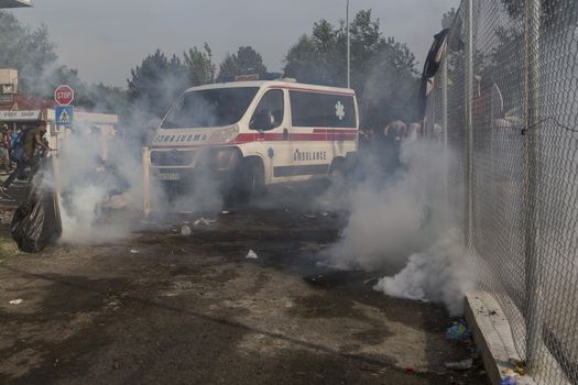 SERBIA, Horgos: Smoke fills the air as Hungarian police fire tear gas and water cannons into the refugees in the Serbian border town of Horgos on September 16, 2015, after Hungary closed its border in an effort to stem the wave of refugees entering the country. 