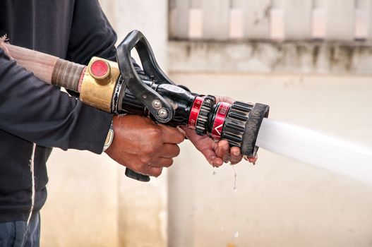 Hand of Firefighter at works with water cannon