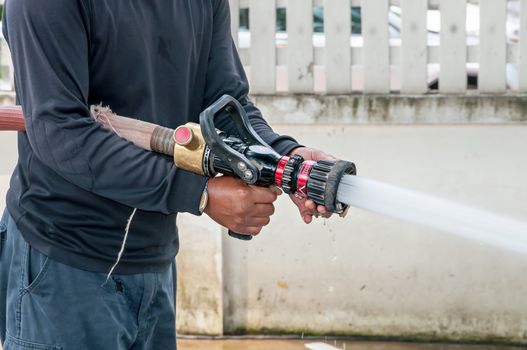 Hand of Firefighter at works with water cannon