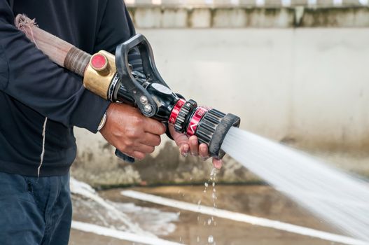 Hand of Firefighter at works with water cannon