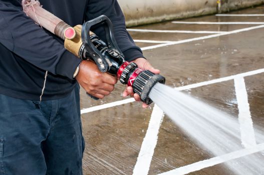 Hand of Firefighter at works with water cannon