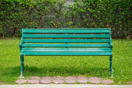 green chair in the park with lawn in the background