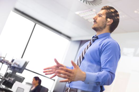 Business man making a presentation at office. Business executive delivering a presentation to his colleagues during meeting or in-house business training. Business and entrepreneurship.