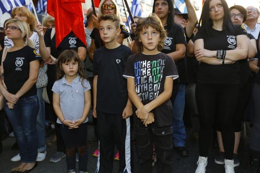 GREECE, Athens: Children watch on as Greece's far-right Golden Dawn party holds an election rally in Athens on September 16, 2015, four days ahead of the country's snap national election. 