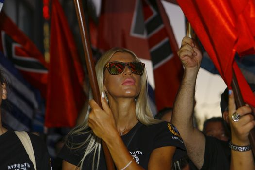 GREECE, Athens: A woman holds a flag as Greece's far-right Golden Dawn party holds an election rally in Athens on September 16, 2015, four days ahead of the country's snap national election. 