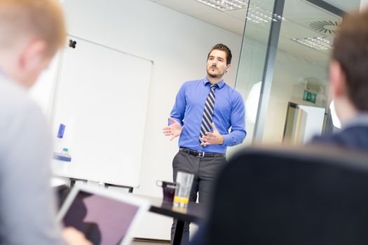 Workplace in modern office with business people brainstorming. Businessman working on laptop during the meeting.