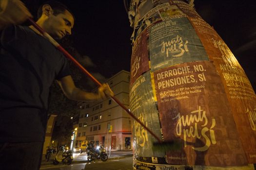 SPAIN, Barcelona: An activist from the pro-independence coalition Junts pel Si (Together for Yes) sticks up posters around Barcelona on the evening of September 16, 2015. Pro-independence groups are rallying their supporters ahead of the Catalonian parliamentary election, taking place on September 27.