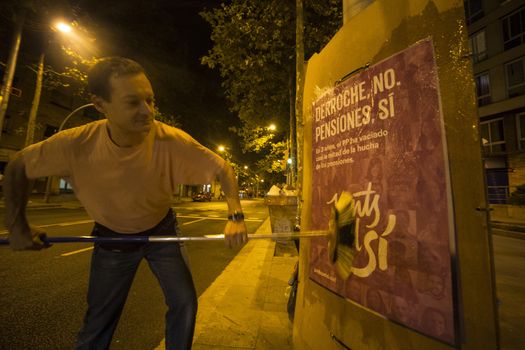 SPAIN, Barcelona: An activist from the pro-independence coalition Junts pel Si (Together for Yes) sticks up posters around Barcelona on the evening of September 16, 2015. Pro-independence groups are rallying their supporters ahead of the Catalonian parliamentary election, taking place on September 27.