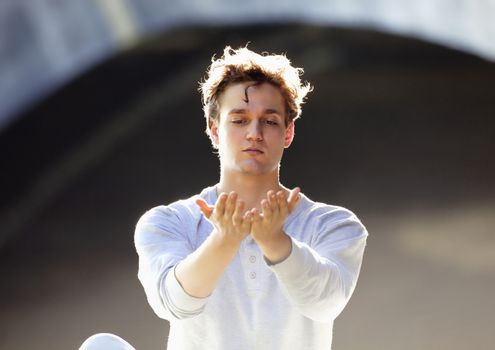 Portrait of a Young Man Exercising Yoga Outdoors.