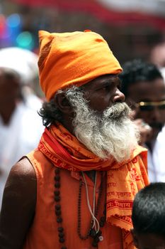An elderly Indian pilgrim in traditional Hindu clothes, during a huge pilgrimmage