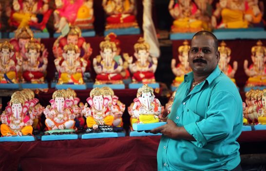 A man selling Lord Ganesh idols on the eve of Ganesh festival in India. The festival involves thousands of visitors from all over the world every year, in the main celebration city - Pune. 