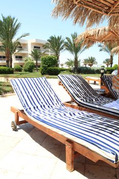 Photo of two striped deck chair in front of a hotel