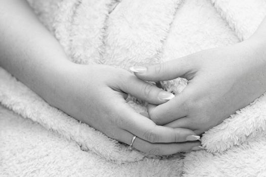 Close up photo of the bride hand in her dress