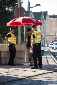 GERMANY, Simbach am Inn: Policemen talk to a refugee on a street in Simbach am Inn, in south-eastern Germany on September 17, 2015.  