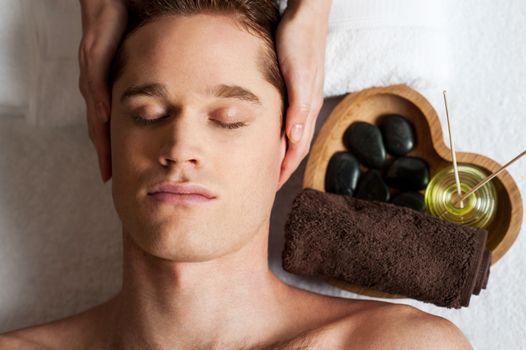 Relaxed man getting a face  massage at day spa