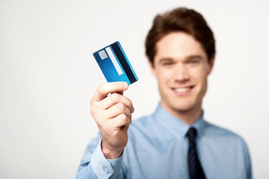 Smiling male executive showing his credit card