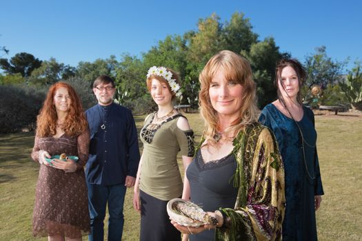 Group of Caucasian polytheists with smudge sticks standing outdoors