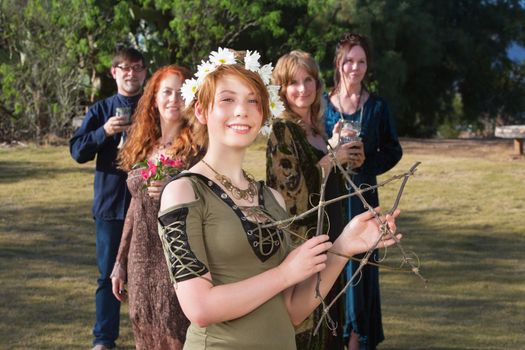 Young pagan woman with group holding a stick pentagram