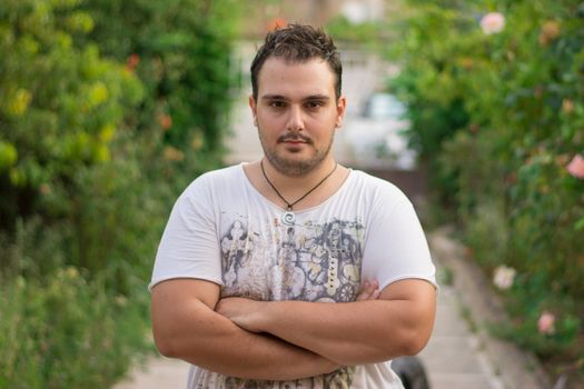 Young man standing in a confident look outdoors.