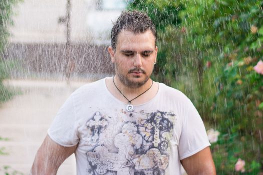 Man standing with his eyes closed in the rain.