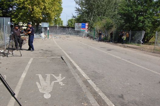 SERBIA, Horgo�: Guards stand near a razor-wire fence at the Serbia-Hungary border in Horgo�, Serbia on September 17, 2015. Recently the migrants have clashed with police forcing the police to use tear gas and water cannons to hold the refugees at bay. The migrants demanded that the razor-wire fence be opened, which would allow them to continue their journey though Europe. 