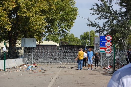 SERBIA, Horgo�: Migrants gather and at a razor-wire fence in Horgo�, Serbia on September 17, 2015. Recently the migrants have clashed with police forcing the police to use tear gas and water cannons to hold the refugees at bay. The migrants demanded that the razor-wire fence be opened, which would allow them to continue their journey though Europe. 