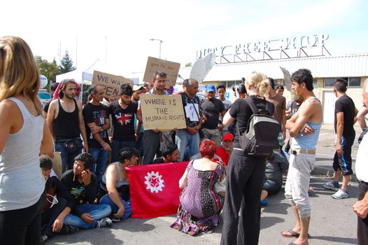 SERBIA, Horgo�: Migrants gather holding signs and flags in Horgo�, Serbia on September 17, 2015. Recently the migrants have clashed with police forcing the police to use tear gas and water cannons to hold the refugees at bay. The migrants demanded that the razor-wire fence be opened, which would allow them to continue their journey though Europe. 