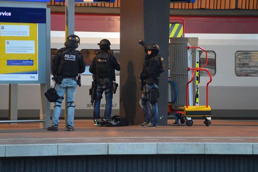 NETHERLANDS, Rotterdam: Members of a special unit of Dutch police stand guard near a Thalys train on a platform of Rotterdam central station, on September 18, 2015, as a man has locked himself in the train'sbathroom. The Thalys plus several platforms have been evicted.