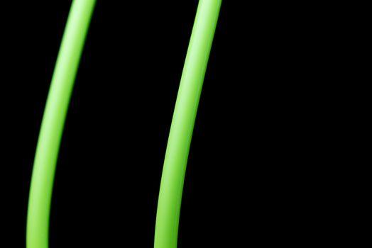 An abstract macro shot of green lines on a pure black background.