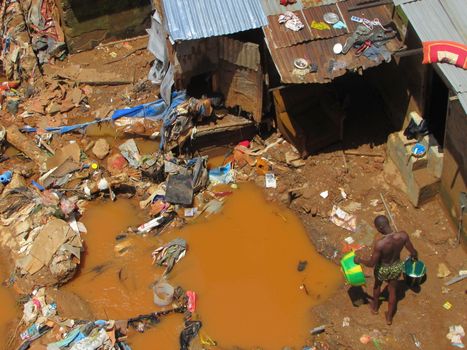 SIERRA LEONE, Freetown: Severe flooding that hit Freetown, Sierra Leone this week has left four people dead and is posing a serious risk of Ebola spreading. Residents at Congo Cross Bridge worked to dry out their homes and contain the spread of the disease on September 17, 2015. 