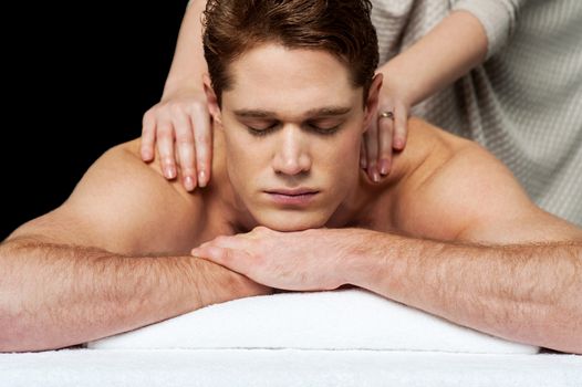 Young man getting his shoulder massaged