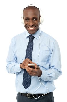 Relaxed male executive enjoying music on mobile phone