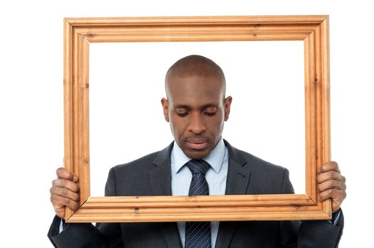 Worried businessman looking down with picture frame 