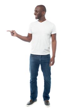 Full length of casual man pointing to copy space