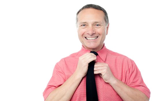 Happy businessman adjusting his necktie