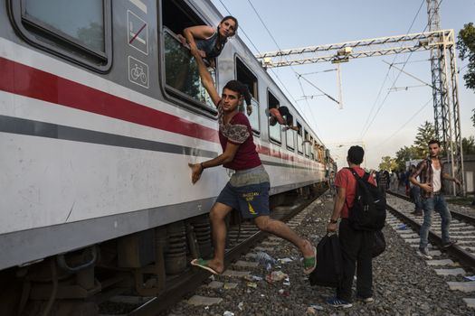 CROATIA, Tovarnik: A refugees hangs from a train at the railway station in Tovarnik, Croatia near the Serbian-border on September 18, 2015. Refugees are hoping to continue their journey to Germany and Northern Europe via Slovenia 