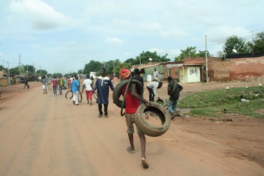 BURKINA FASO, Ouagadougou : Protestors cary tires to be burned in Ouagadougou, Burkina Faso, on September 18, 2015. Protests have sparked in Ouagadougou after Presidential guard officers seized power in a coup.