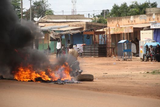 BURKINA FASO, Ouagadougou : Tires burn near the presidential palace in Ouagadougou, Burkina Faso, on September 18, 2015. Protests have sparked in Ouagadougou after Presidential guard officers seized power in a coup.