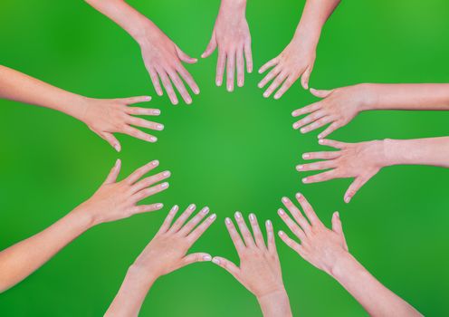 Many teenage girls hands joining in circle isolated on green background