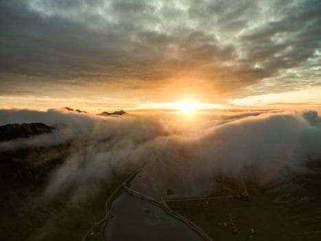 Midnight sun above clouds on Lofoten islands in Norway, aerial view