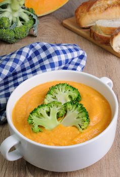 Pumpkin soup puree with cream in a dish with broccoli