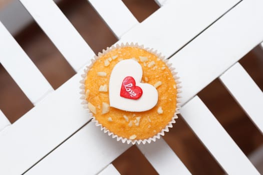 valentine's day muffin with red and white hearts on a white wooden table